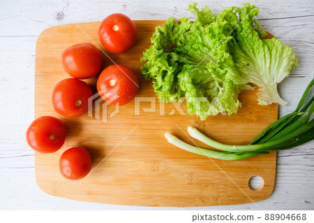 Fresh vegetables lie on a wooden cutting board Fresh vegetables lie on a wooden cutting board 88904668