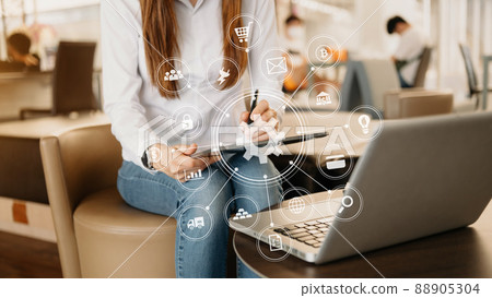 Hands of woman using mobile phone in modern office with laptop and digital tablet computer with VR icon 88905304