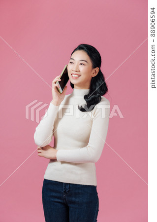 Cheerful woman talking on the phone isolated on a pink background 88906594