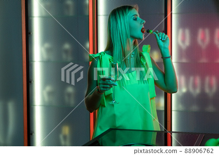 Young blonde enjoying light snack with champagne in home kitchen Young blonde enjoying light snack with champagne in home kitchen 88906762