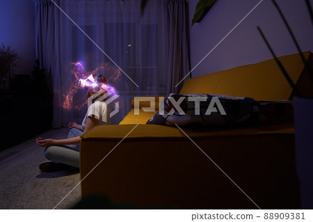 Woman uses virtual reality glasses to relax and meditate. Elements of this image furnished by NASA. 88909381