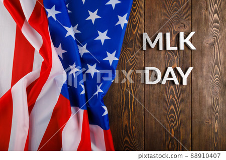 the word MLK day laid with silver metal letters on wooden surface with crumpled USA flag at left side the word MLK day laid with silver metal letters on wooden surface with crumpled USA flag at left side 88910407
