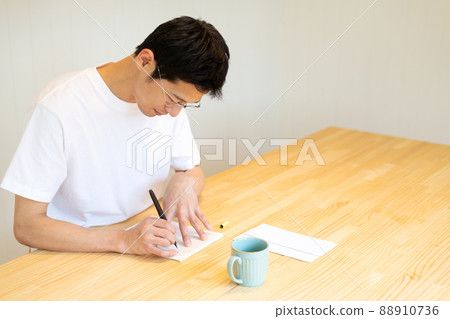 A man writing a letter with a brush pen 88910736
