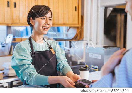 通過智能手機付款接收外賣咖啡的女性 通過智能手機付款接收外賣咖啡的女性 88911864