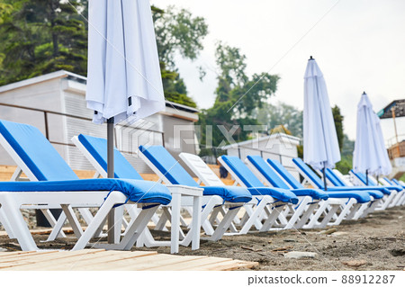 Sun loungers with blue mattresses on the beach 88912287