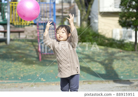 Girl playing with a ball in the park 88915951