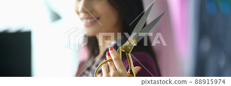 Young woman holds in hands professional seamstress scissors 88915974