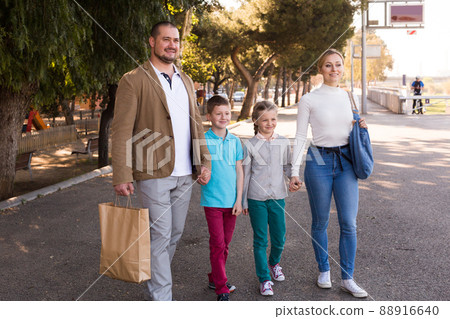 young parents with two children walking on the street 88916640