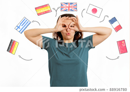 English Language Day. Portrait of a woman making a funny grimace on her face. White background with flags of different countries.The concept of choosing to study foreign languages English Language Day. Portrait of a woman making a funny grimace on her face. White background with flags of different countries.The concept of choosing to study foreign languages 88916780