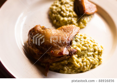 dish duck leg with green perlotto served on a white plate dish duck leg with green perlotto served on a white plate 88916856