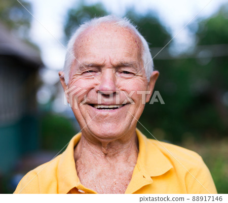 Portrait of an elderly man 70 years old in his garden on summer sunny day Portrait of an elderly man 70 years old in his garden on summer sunny day 88917146