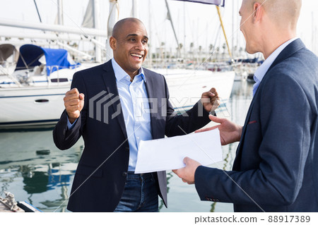 two men in suits buy and sell a yacht in the seaport two men in suits buy and sell a yacht in the seaport 88917389