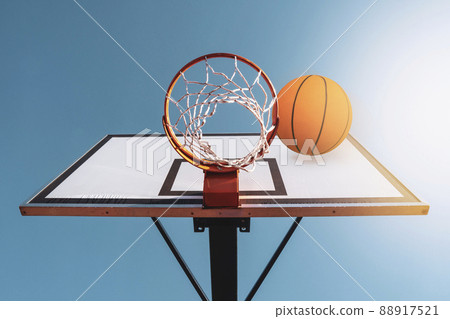 Orange basketball ball falling into the hoop Orange basketball ball falling into the hoop 88917521
