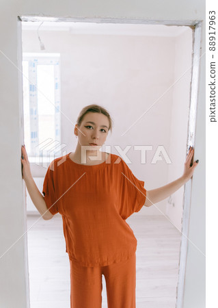 Portrait of young caucasian woman in red cloth. 88917963