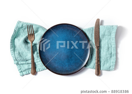 Cutlery with a blue plate. A fork, a knife, and a dish on a teal napkin Cutlery with a blue plate. A fork, a knife, and a dish on a teal napkin 88918386