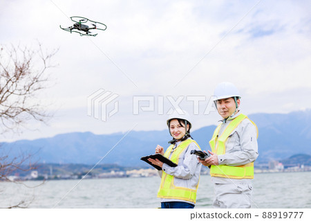 Workers operating drones 88919777