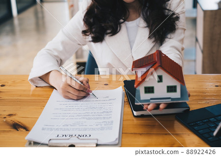 Close up of Business woman pointing and signing agreement for buying house. Bank manager concept. 88922426