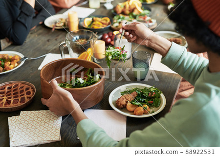 Close-up of teenage boy eating vegetable salad with chicken at dining table during holiday dinner with family Close-up of teenage boy eating vegetable salad with chicken at dining table during holiday dinner with family 88922531