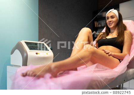 Beautiful woman lies on a couch waiting for a laser hair removal procedure Beautiful woman lies on a couch waiting for a laser hair removal procedure 88922745