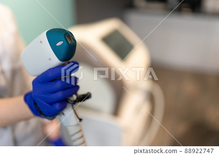 Cosmetologist with a laser for hair removal 88922747