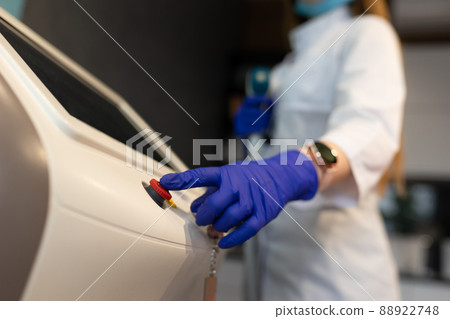 Woman presses the red button on a laser epilation machine Woman presses the red button on a laser epilation machine 88922748
