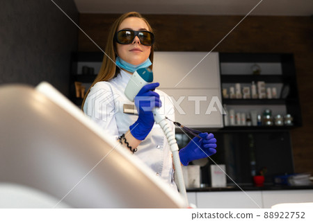 Female cosmetologist with a laser for hair removal Female cosmetologist with a laser for hair removal 88922752