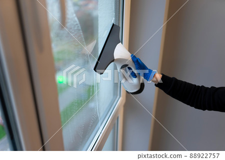 Window cleaning with electric vacuum cleaner. Clean windows concept Window cleaning with electric vacuum cleaner. Clean windows concept 88922757