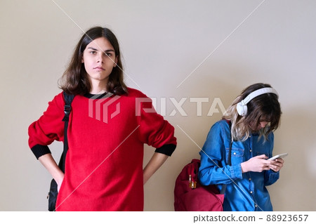 Teenagers students guy and girl with backpacks on background of light wall 88923657