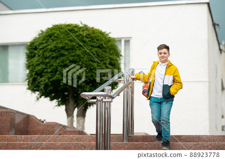 Schoolboy with backpack going down the stairs from school. Teenager comes home after class 88923778