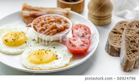 English breakfast with fried eggs, bacon, beans, tomatoes, spices and herbs English breakfast with fried eggs, bacon, beans, tomatoes, spices and herbs 88924796