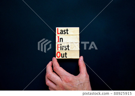 LIFO last in first out symbol. Concept words LIFO last in first out on wooden blocks. Beautiful black table black background. Businessman hand. Business LIFO last in first out concept. Copy space. 88925915