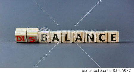 Balance or disbalance symbol. Turned cubes and changed the word disbalance to balance. Beautiful grey background, copy space. Business, balance or disbalance concept. 88925987