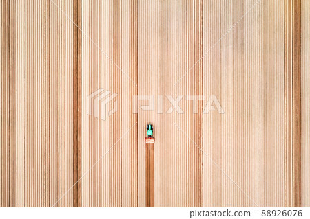 Lonely tractor on agricultural field with rows of plowed soil 88926076