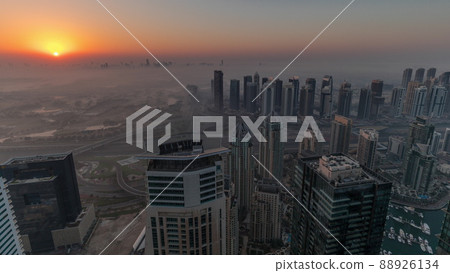 Panorama of Dubai Marina with JLT skyscrapers and golf course during sunrise timelapse, Dubai, United Arab Emirates. Panorama of Dubai Marina with JLT skyscrapers and golf course during sunrise timelapse, Dubai, United Arab Emirates. 88926134
