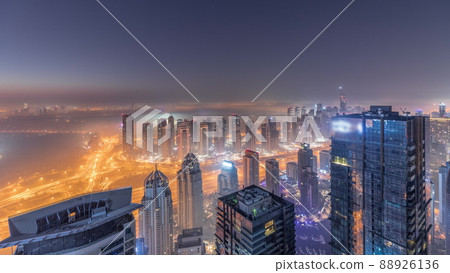 Panorama of Dubai Marina with JLT skyscrapers and golf course night to day timelapse, Dubai, United Arab Emirates. Panorama of Dubai Marina with JLT skyscrapers and golf course night to day timelapse, Dubai, United Arab Emirates. 88926136