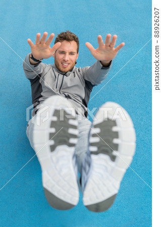 Floor workout abs situp exercise fitness man doing leg lift toe touch sit-up workout strength training at outdoor gym. Athlete working out crunches exercises for stomach muscles and weight loss 88926207