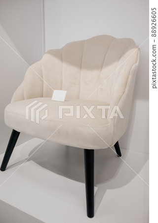 White armchair in furniture showroom. Showroom of modern upholstered furniture White armchair in furniture showroom. Showroom of modern upholstered furniture 88926605