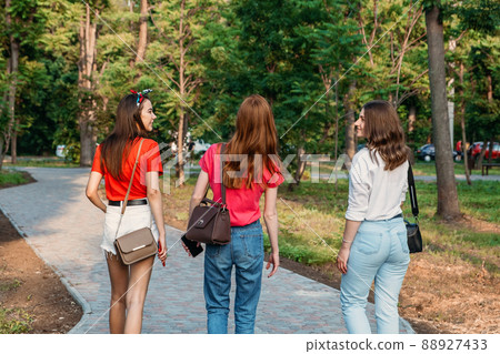 Group of girl friends jumping outdoors on sunset city public park. Young multi-ethnic hipster friends dancing at summer park. Group of women friends hugging and ejoying the sunset in outdoor nature Group of girl friends jumping outdoors on sunset city public park. Young multi-ethnic hipster friends dancing at summer park. Group of women friends hugging and ejoying the sunset in outdoor nature 88927433