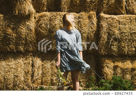 Agritourism and Farm Tours, Farm Cottagecore Weekend Trip. Farm Trips For Peaceful Weekend. A woman in rustic dress and with wildflowers in front of straw bales Agritourism and Farm Tours, Farm Cottagecore Weekend Trip. Farm Trips For Peaceful Weekend. A woman in rustic dress and with wildflowers in front of straw bales 88927435