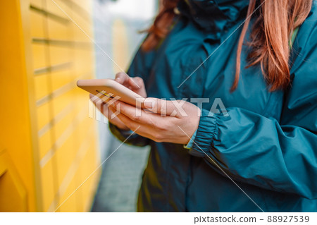 Woman picks up mail from automated self-service post terminal machine. Mail delivery, technology and post service concept Woman picks up mail from automated self-service post terminal machine. Mail delivery, technology and post service concept 88927539