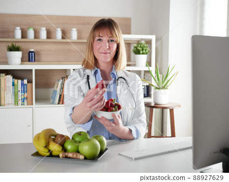 Female nutritionist holding a strawberries fruit in office studio 88927629