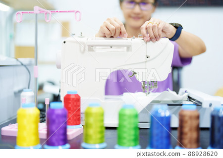 Embroidery, handicrafts, SME, family business Portrait of an Asian female designer picking up sewing threads for Design patterns using automatic embroidery machines according to customer orders Embroidery, handicrafts, SME, family business Portrait of an Asian female designer picking up sewing threads for Design patterns using automatic embroidery machines according to customer orders 88928620