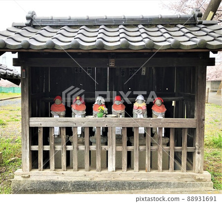 Rokujizo with a red bib housed in a small hall with a tiled roof 88931691