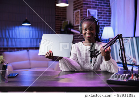 POV of online blogger filming laptop review video on camera, talking about computer for social media channel. Female content creator recording product recommendation in studio. 88931882