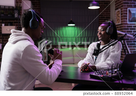 Web influencers having fun with live broadcast discussion on podcast station, streaming internet vlog and chatting for social media channel. Creative people talking on episode show, recording talk. 88932064
