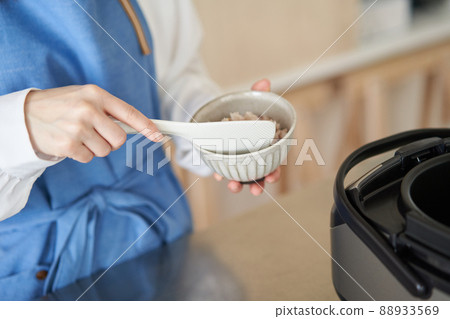 A woman who puts millet rice in a bowl 88933569
