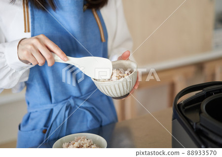 A woman who puts millet rice in a bowl 88933570