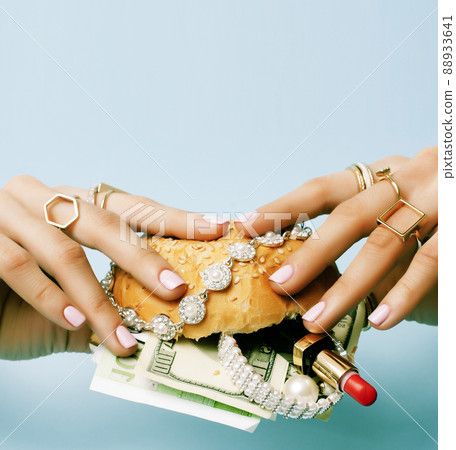 woman hands holding hamburger with money, jewelry, cosmetic 88933641