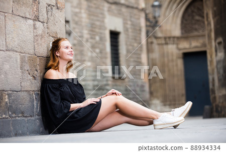 smiling female sitting near the stone wall smiling female sitting near the stone wall 88934334