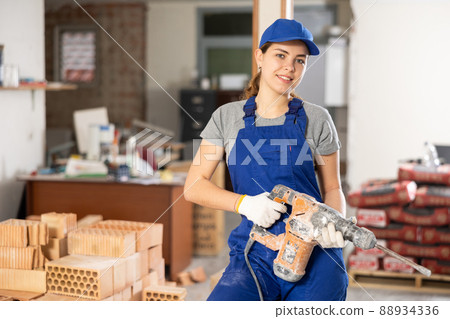 Young woman construction worker standing inside apartment Young woman construction worker standing inside apartment 88934336